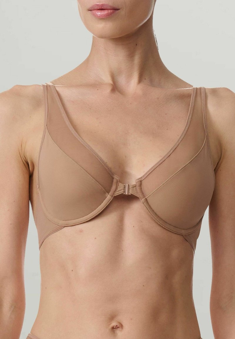 Reggiseno beige con coppe modellate, spalline regolabili e chiusura frontale. Presenta una texture liscia e un design senza cuciture per comfort e vestibilità.