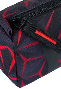 Borsa con motivo geometrico nero e rosso, dalla superficie texturizzata, dotata di chiusura con zip e una tracolla nera con un accento rosso.