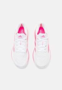 Baskets de sport blanches avec des accents roses, dessus en mesh et détails texturés. Comprend des lacets blancs, un col rembourré et une marque sur la languette.