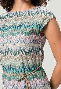 Sukienka z wielokolorowym wzorem w zygzaki w odcieniach niebieskiego, zielonego i różowego; uszyta z fakturowanej tkaniny z przewiązanym paskiem w talii.