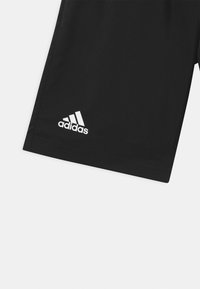 Schwarze Sportshorts aus synthetischem Material, mit einem elastischen Bund und einem weißen Adidas-Logo auf der unteren linken Seite.