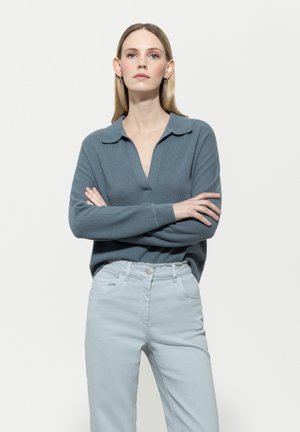 Light blue sweater with a V-neck and collar, paired with light gray pants featuring front pockets and belt loops. Smooth, soft textures.