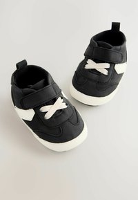 Czarne sneakersy z białymi akcentami, pasek na rzep i białe sznurowadła. Wykonane z syntetycznego materiału, z teksturowaną białą gumową podeszwą.