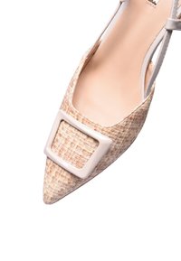 Scarpa a punta con tomaia in tessuto beige intrecciato, dettaglio luccicante della fibbia beige e una sottile cinghia alla caviglia. Interno liscio e design leggero.