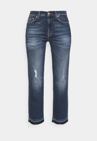 Jeans in denim blu scuro con vestibilità dritta, caratterizzati da dettagli strappati, orli sfrangiati e stile classico a cinque tasche.