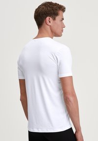 White cotton t-shirt, short sleeves, round neckline, smooth texture, fitted design, plain without patterns, basic style.