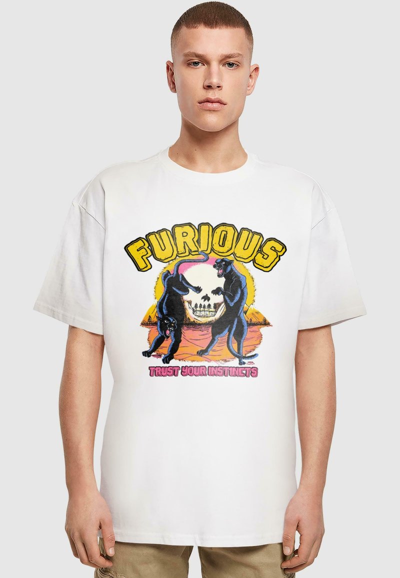 Bílý bavlněný tričko s grafickým designem zobrazujícím dva černé pantery a lebku, s nápisem "FURIOUS" ve žluté barvě a "TRUST YOUR INSTINCTS" v růžové.