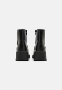 Sorte lær ankle boots med en glat finish, kraftig hæl og sidelukninger. Rent design, strømlinet form uden synlige mønstre.