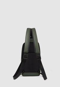 Mochila verde y negra con un diseño elegante, que cuenta con correas acolchadas, respaldo de malla texturizada y materiales contrastantes para mayor durabilidad.