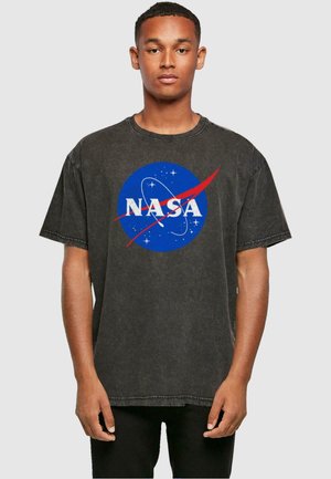 Black oversized T-shirt featuring a blue NASA logo with white lettering and red accents. Cotton material with a faded texture.