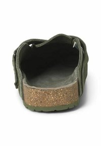 Zapato con suela de corcho y parte superior de ante verde oscuro. El diseño de espalda abierta presenta un interior texturizado y costuras a lo largo de los lados.