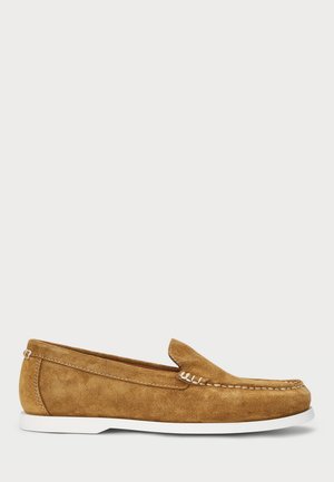 Brune semskede loafers med hvit gummisåle, slip-on design, sydd detalj på overdelen, og rund tå. Minimalistisk stil.