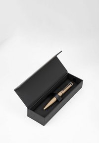 Beige pen met zilveren accenten in een zwarte presentatiedoos, beveiligd met een zwarte band. Doos heeft een gladde, matte afwerking.