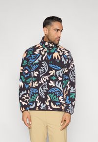 Pulóver de forro polar con cuello alto, con base azul marino oscuro y patrones abstractos vibrantes de hojas en verde, azul, melocotón y crema.