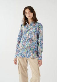 Blusa a fantasia floreale in tessuto blu, rosa e verde. Caratterizzata da una parte anteriore plissettata, chiusura con bottoni e colletto alto. Maniche lunghe con polsini.