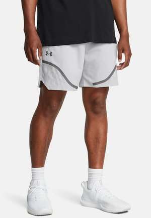 Jasnoszare sportowe szorty o siateczkowej fakturze, z zakrzywionym czarnym akcentem i małymi perforacjami po bokach, zestawione z białymi trampkami.