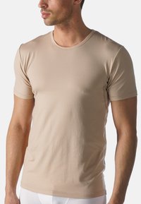 Beige T-shirt met korte mouwen, gemaakt van zacht materiaal, met een ronde hals, een gladde textuur en minimale stiksels.