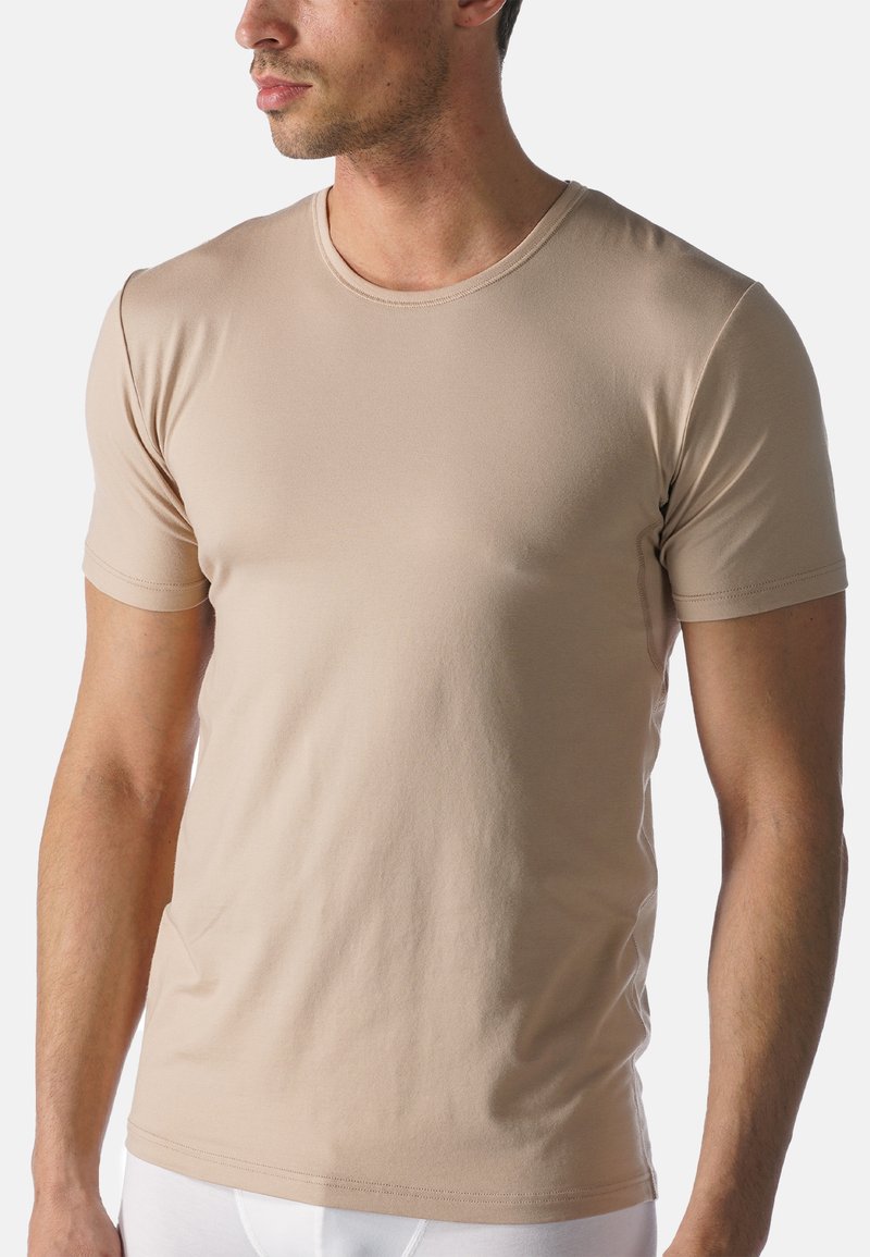 Beige T-shirt met korte mouwen, gemaakt van zacht materiaal, met een ronde hals, een gladde textuur en minimale stiksels.