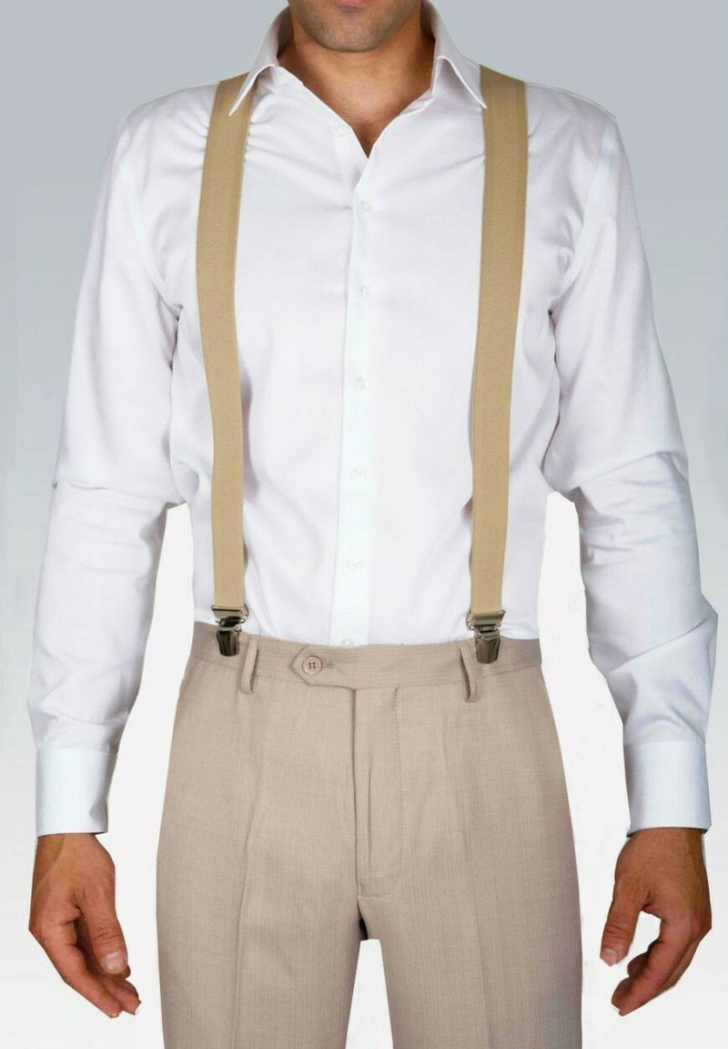 Chemise blanche à col, bretelles beiges et pantalon plissé beige clair avec fermeture à boutons. Tissu lisse, coupe classique, quincaillerie minimale.