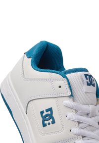 Vit lädersneaker med turkosa accenter, med en vadderad krage, mesh-fodring och en logotyp på sidan. Platta snören och texturerad sula.