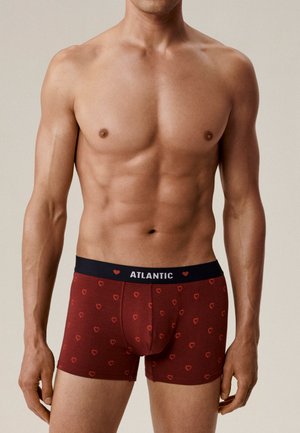 Czerwone bokserki z małymi wzorami serc, czarna elastyczna talia z napisem "ATLANTIC", dopasowany krój, gładka faktura tkaniny.
