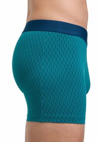 Boxer da uomo in tessuto verde acqua con un motivo testurizzato di sottili linee verticali. Presenta un elastico in vita di colore navy.