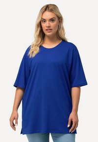 Royal blue oversized t-shirt made of soft cotton, featuring a round neckline and short sleeves, with side slits for added comfort.