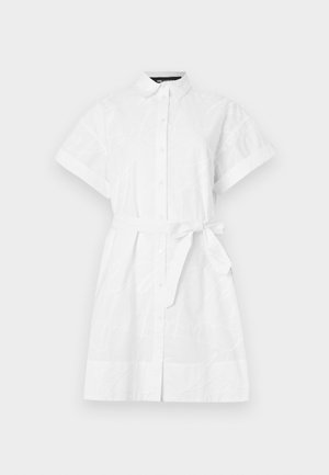 Balta marškinių suknelė su trumpomis rankovėmis, mygtukų užsegimu ir derančiu audiniu diržu. Pasižymi subtiliais atspalviais raštais ir klasikinio kirpimo apykakle.