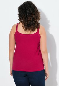 Enganliegendes, burgunderfarbenes Tanktop aus weicher Baumwolle, mit dünnen Schultern Trägern und einem einfachen Rundhalsausschnitt, sowie einem geraden Saum.