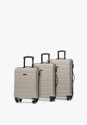 Drie harde koffers in lichtgrijs, met een ribbelontwerp, zwarte handvaten en spinnerwielen voor gemakkelijke mobiliteit.