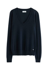 Marineblå v-hals sweater i blødt strikmateriale, med lange ærmer samt ribbede manchetter og kant. Inkluderer lille metal logo detalje på siden.