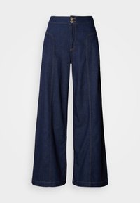 Τζιν παντελόνι φαρδύ στο τελείωμα σε σκούρο ντένιμ με αντίθετη πορτοκαλί ραφή, δύο μπροστινές τσέπες και κλείσιμο με διπλό κουμπί στη μέση.