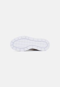 Semelle de chaussure avec une surface en caoutchouc blanc texturé présentant un motif géométrique et un bord supérieur lisse marron. Conception durable et flexible.