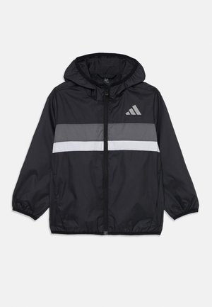 Giacca a vento nera con cappuccio, caratterizzata da strisce orizzontali grigie e bianche, una zip centrale e un logo Adidas grigio.