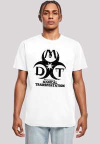 Hvit bomull t-skjorte med en iøynefallende svart grafikk av et rundt logo med "DMT" og teksten "Department of Magical Transportation".