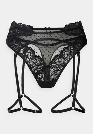 Black lace thong with polka dot detail, scalloped edges, and adjustable straps. Features floral pattern and a soft mesh texture.