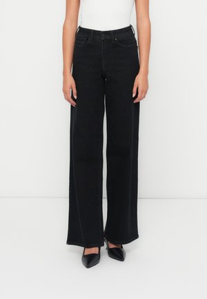 Videbeinte svarte denimjeans med høy midje, rett snitt og minimalistisk design. Har klassisk femlommers styling og tonale sømmer.