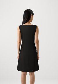 Vestido preto sem mangas com decote quadrado, corpete ajustado e barra rodada, feito de um tecido suave e leve.