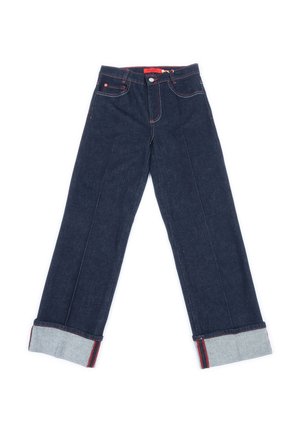 Jeans in denim blu scuro con cuciture rosse, orli risvoltati che mostrano un tessuto interno più chiaro e chiusura frontale con bottone.