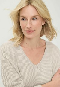 Lichtgrijze gebreide trui met een V-hals, een gestructureerd patroon en driekwart mouwen, gemaakt van een zachte en ademende stof.