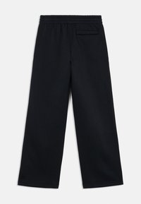 Fekete, bőszárú nadrág puha anyagból, gumis derékrésszel és egyetlen hátsó zsebbel. Tiszta, minimalista dizájn.