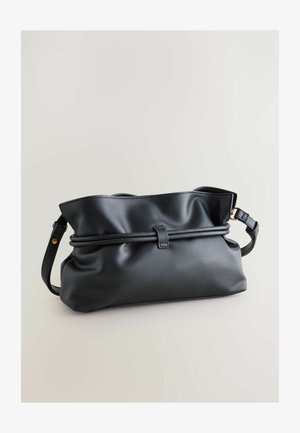 Mustan nahkaolkalaukun pehmeä, teksturoitu pinta. Siinä on rypistetty muotoilu, säädettävä hihna ja keskeinen taitosyksityiskohta. Kultahtava koriste.