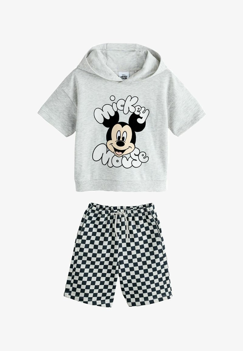 Haut à capuche gris clair à manches courtes avec le visage de Mickey Mouse et un texte, associé à un short à cordon noir et blanc à motifs à carreaux.