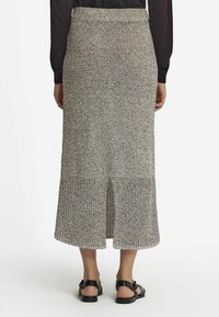 Stickad midi kjol i svart och vitt, med en åtsittande midja och slits bak. Texturerad tyg med en jämn, mjuk finish.