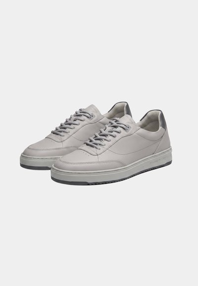 Ζεύγος ανοιχτογκρι δερμάτινων sneakers χαμηλού προφίλ με γκρι κορδόνια και σκούρες γκρι επαναφορές στη φτέρνα, σε λευκό φόντο.