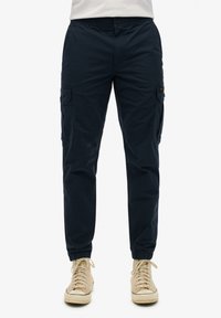 Pantalons cargo bleu marine avec poches latérales, poignets élastiques et taille ajustée. Confectionnés en tissu doux, ils présentent un design décontracté adapté à diverses occasions.