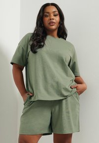 Olivgrön bomullsjersey-t-shirt med korta ärmar och avslappnad passform, i kombination med matchande shorts som har sidofickor.