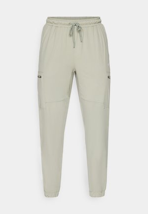Pantalons de jogging vert clair en tissu léger, dotés d'une taille élastique, d'un cordon de serrage et de deux poches latérales.
