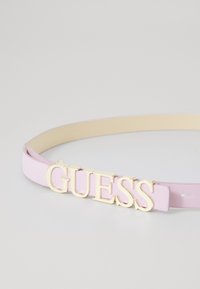 Rosa Leder-Gürtel mit einem goldfarbenen "GUESS"-Logo als zentralem Akzent. Glatte Textur mit klassischem Schnallendesign.