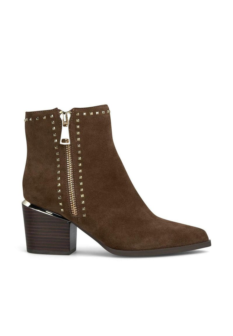 Botín de ante marrón hasta el tobillo con punta afilada, tachuelas en tono dorado a lo largo del lateral y cierre de cremallera. Presenta un chunky heel de madera.